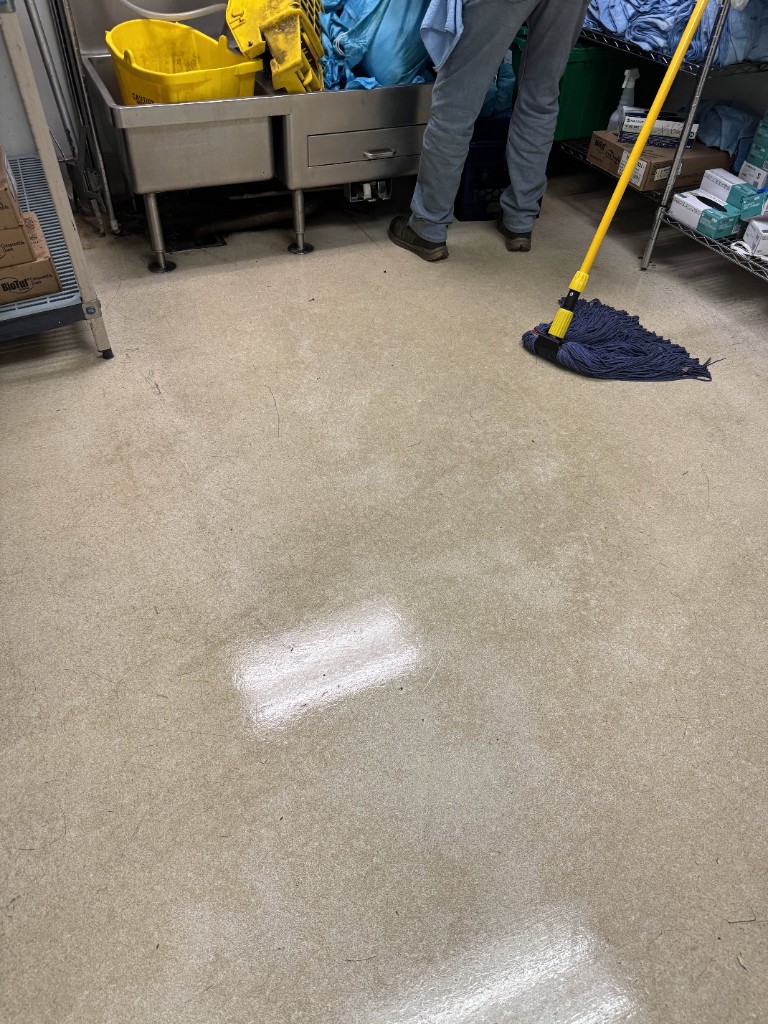 Barak Group crew member mopping a facility floor on site